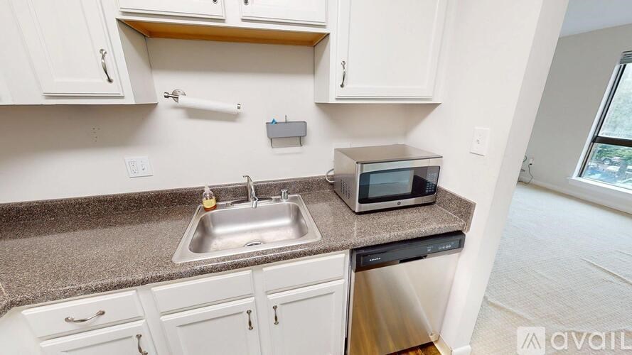 A kitchen with white cabinets and a granite countertop.