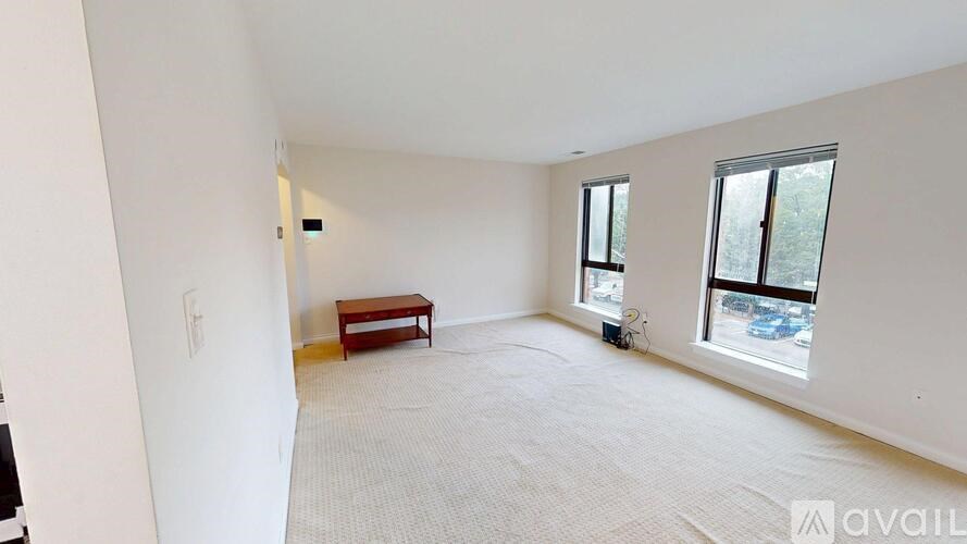 A spacious room with a bench and two windows.