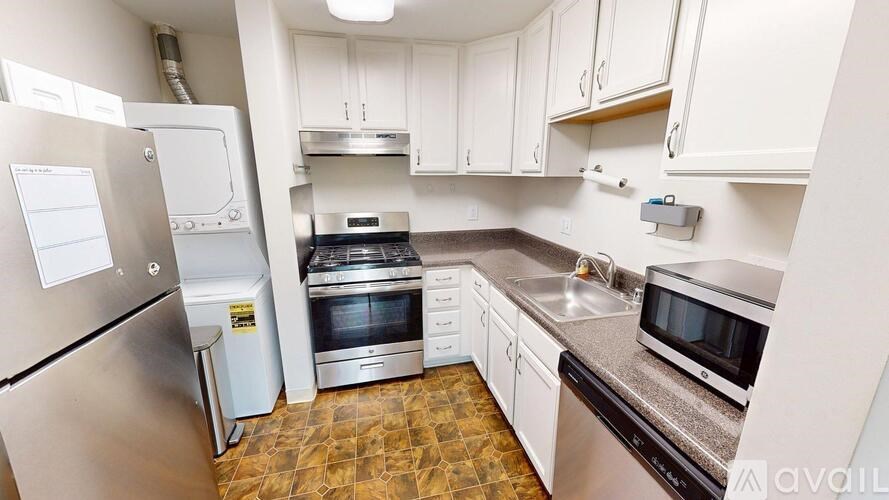 A kitchen with a refrigerator, oven, and microwave.