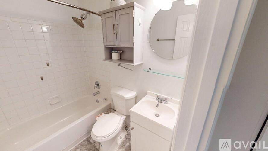 A white bathroom with a toilet, sink, and bathtub.