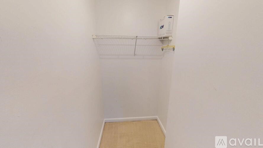 A small, empty room with a shelf and a carpeted floor.
