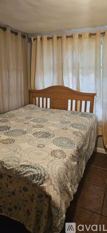 A bed with a wooden headboard and a white and blue patterned bedspread.
