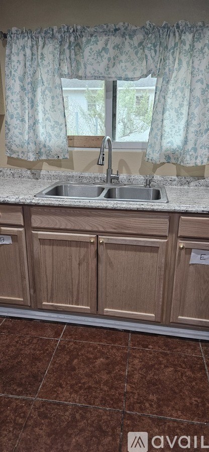 A kitchen with a sink and wooden cabinets.
