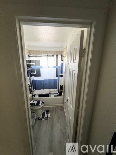 A room with a bed and a desk is visible through an open door.