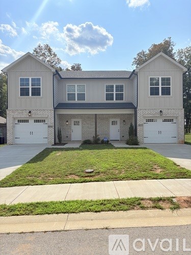 A two-story house with a front yard and a driveway.