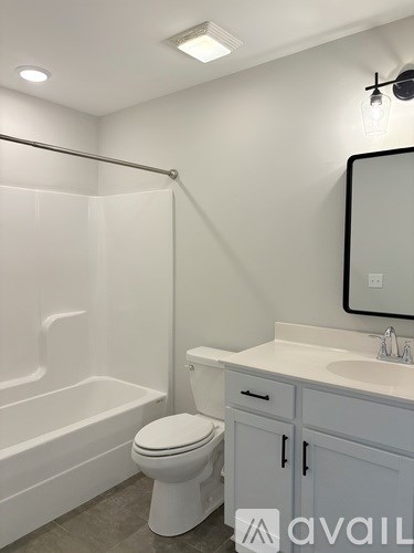 A white bathroom with a toilet, sink, and bathtub.