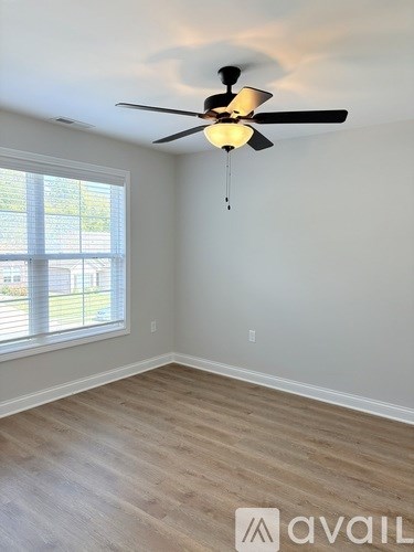 A room with a ceiling fan and a window.