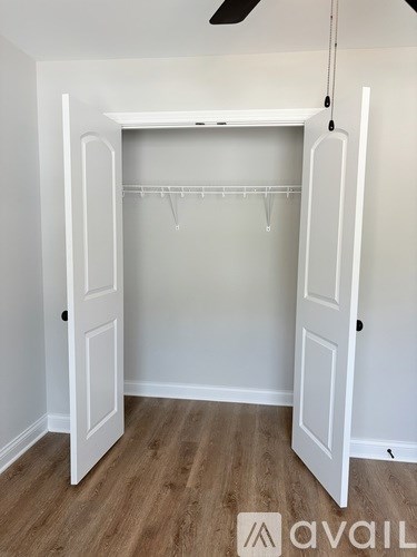 A white closet with a fan on the ceiling.
