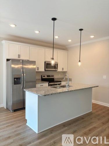A kitchen with a granite countertop and stainless steel appliances.