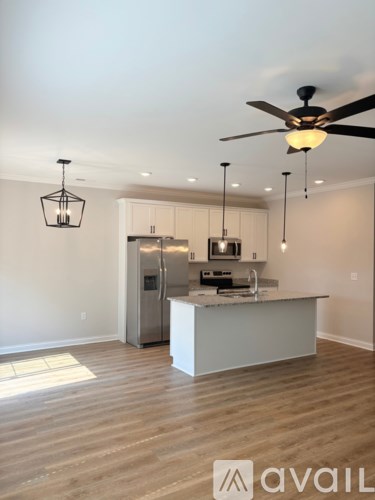 A kitchen with a white island and a ceiling fan.