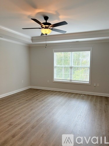 A room with a ceiling fan and a window with blinds.