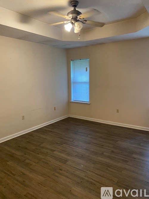 A room with wooden flooring and a ceiling fan.