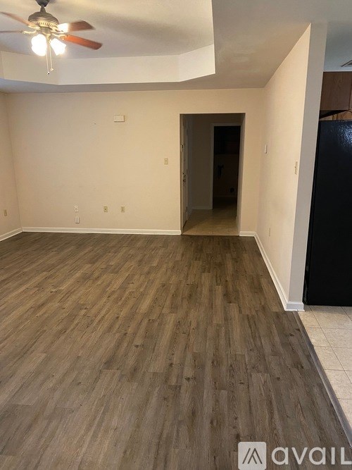 A room with wooden flooring and a ceiling fan.