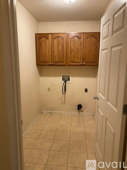 A small room with wooden cabinets and a white door.