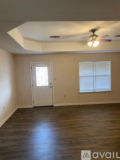 A room with a white door and a window with blinds.