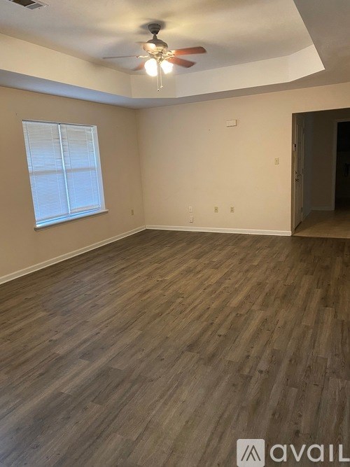A room with wooden flooring and a ceiling fan.