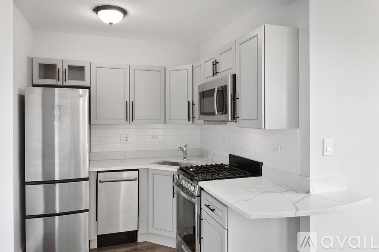 A kitchen with white cabinets and appliances.