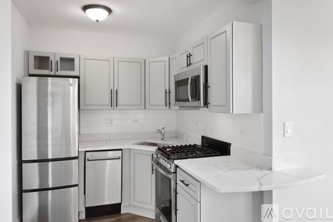 A kitchen with white cabinets and appliances.
