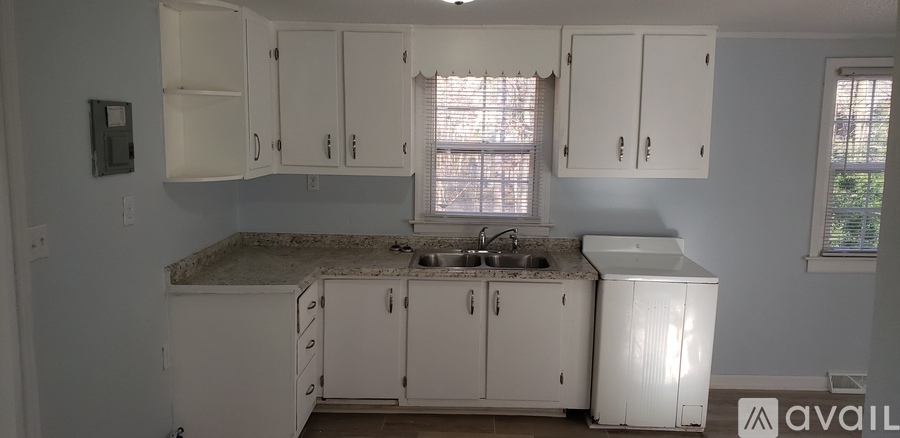 A kitchen with white cabinets and a granite countertop.
