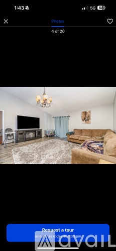 A living room with a couch, a chair, and a television.