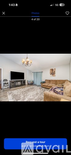 A living room with a couch, a chair, and a television.