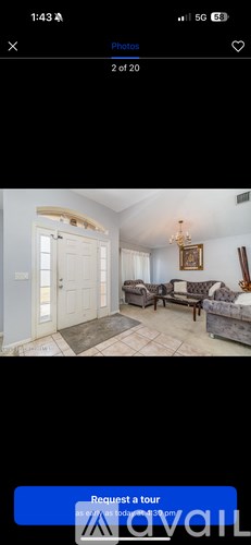 A living room with a couch, a coffee table, and a chandelier.