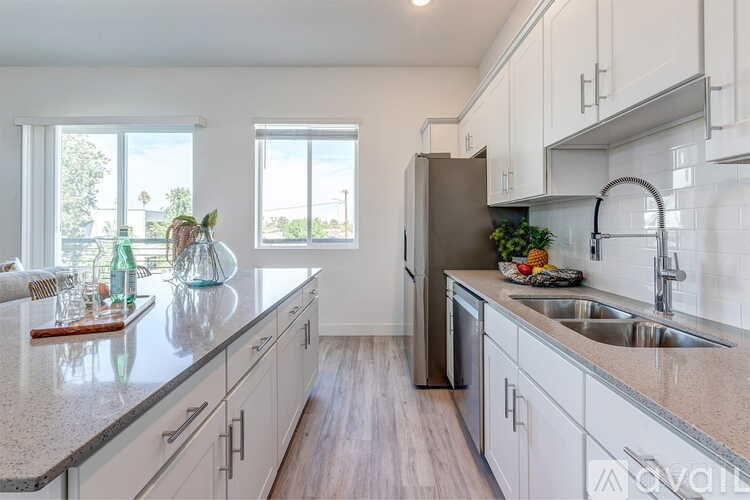A kitchen with a granite countertop and stainless steel appliances.