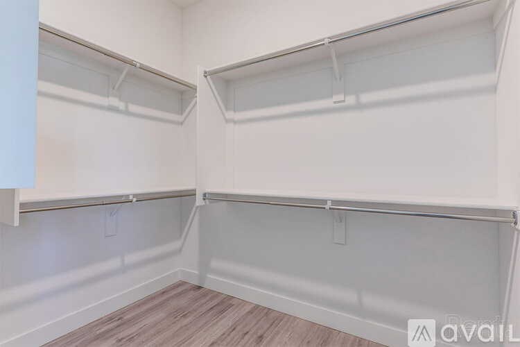 Empty walk-in closet with shelves and a wooden floor.