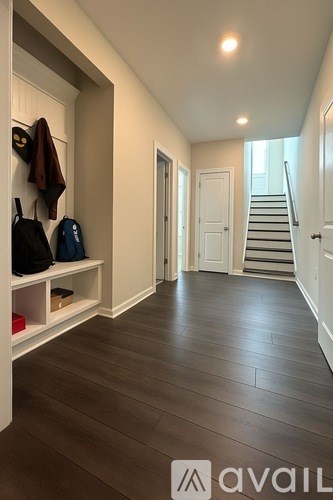 A hallway with a bench and coat hooks.