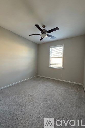 A room with a ceiling fan and a window.