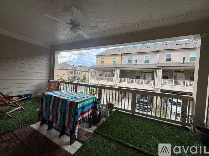 A patio with a table covered in a striped blanket and a fan on the ceiling.
