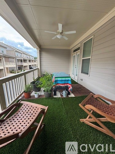 A patio with a wooden chair and a table with a potted plant on it.