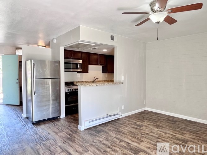 A kitchen with a refrigerator, oven, and microwave.