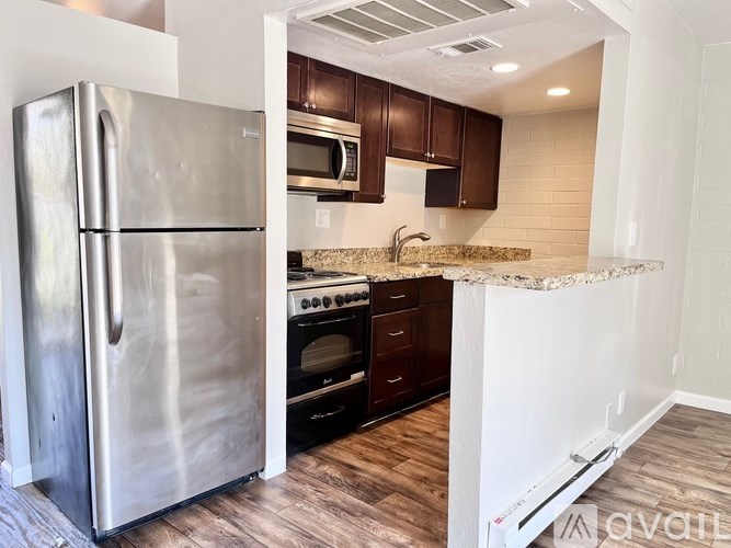 A kitchen with a stainless steel refrigerator and microwave.