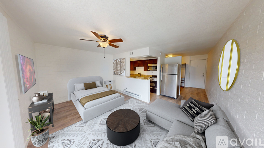A living room with a white couch and a round ottoman.
