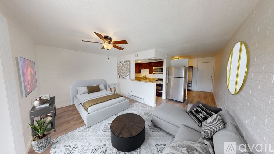 A living room with a white couch and a round ottoman.