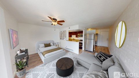 A living room with a white couch and a round ottoman.