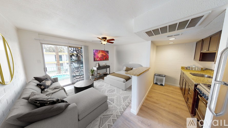 A living room with a grey couch and a yellow circular object on the wall.