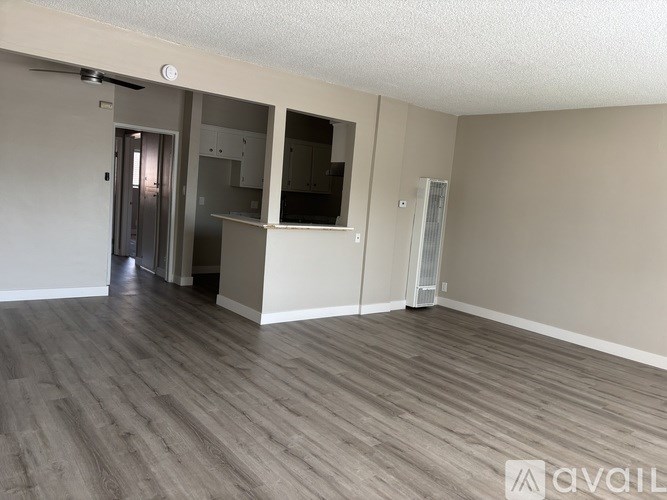 A room with wooden flooring and a ceiling fan.