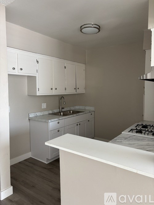 A kitchen with white cabinets and a white counter.