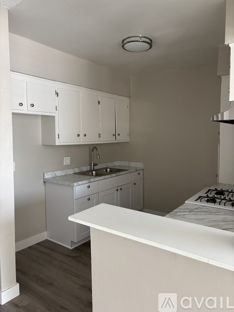 A kitchen with white cabinets and a white counter.