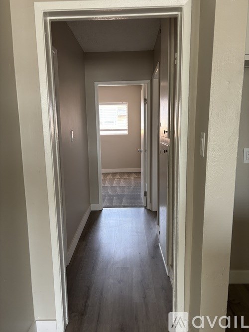 A hallway with a door on the left and a door on the right.