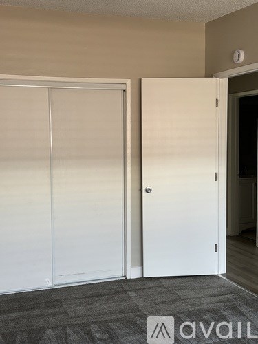 Two white closet doors in a room.