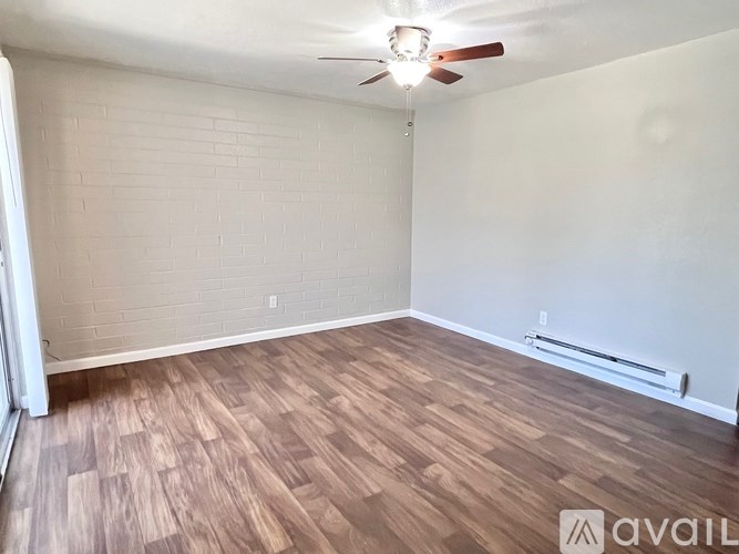 A room with wooden flooring and a ceiling fan.