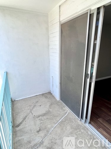 A room with a white wall and a closed door.