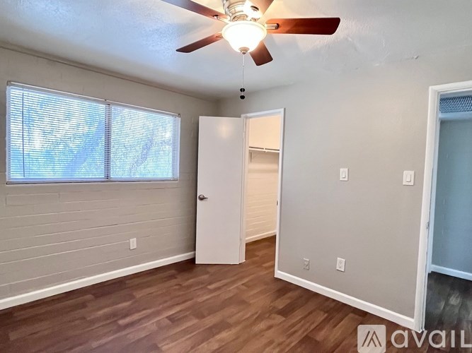 A room with a ceiling fan and a door.