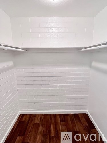 A white tiled kitchen with wood flooring.