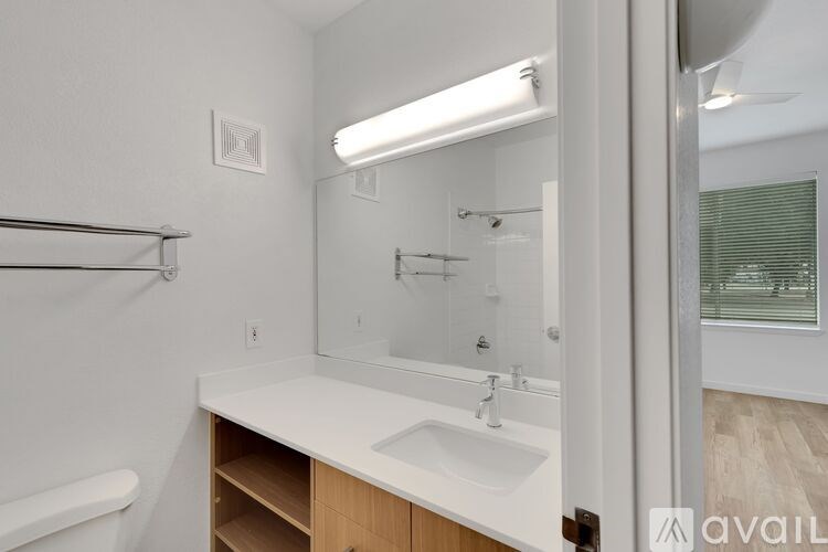A bathroom with a sink, mirror, and a window.