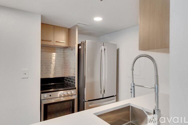 A kitchen with a stainless steel refrigerator and a sink.