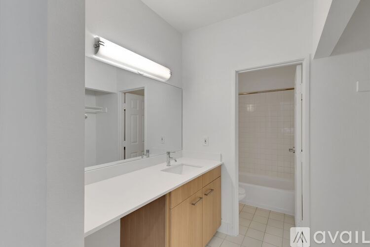 A bathroom with a sink, mirror, and shower.